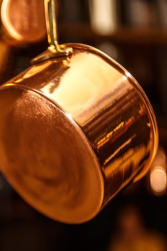 copper pots hanging from a kitchen ceiling