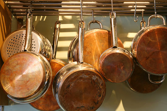 copper saucepans hanging from a rack